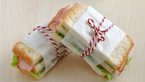 Zwei mit einem Faden zusammengebundene Sandwiches. © fotolia Foto: A Lein