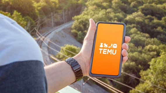 Eine Hand, in der ein Smartphone liegt, darin die App Temu © picture alliance / CHROMORANGE | CHROMORANGE Foto: picture alliance / CHROMORANGE | CHROMORANGE