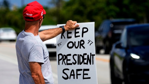 ein Trumpanhänger hält ein Schild in der Hand, auf dem steht: " keep our president safe " © AP Foto: Lynne Sladky