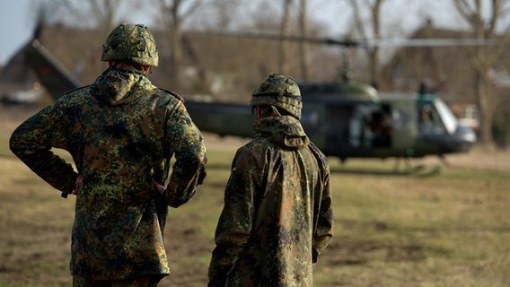 Zwei Reservisten schauen bei einer Katastrophenschutzübung in Hamburg auf einen Hubschrauber. © dpa - Bildfunk Foto: Sven Hoppe