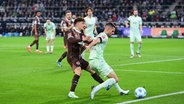 St. Paulis Philipp Treu (l.) und Gladbachs Julian Weigl kämpfen um den Ball. © IMAGO / fohlenfoto 