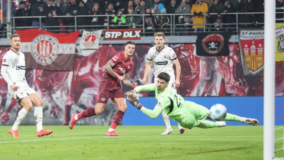 St. Paulis Spieler können einen Treffer von Leipzigs Benjamin Sesko (M.) nicht verhindern. © IMAGO / Jan Huebner 