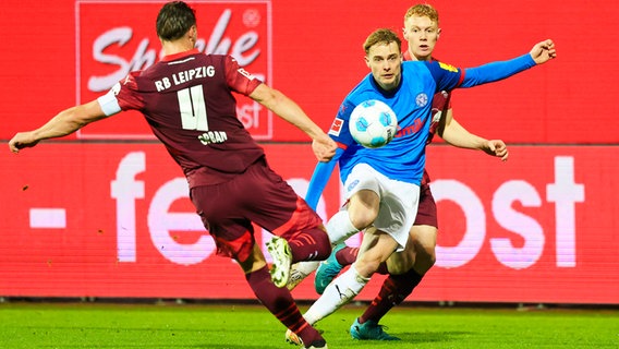 Kiels Finn Porath (M.) und Leipzigs Wili Orban (l.) kämpfen um den Ball. © picture alliance/dpa | Frank Molter 