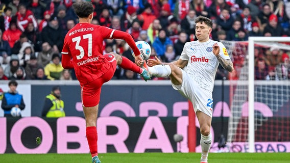 Kiels Nicolai Remberg (r.) und Freiburgs Max Rosenfelder kämpfen um den Ball. © IMAGO / Eibner 