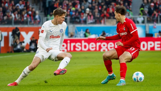 Kiels Phil Harres (l.) und Freiburgs Max Rosenfelder kämpfen um den Ball. © IMAGO / Steinsiek.ch 