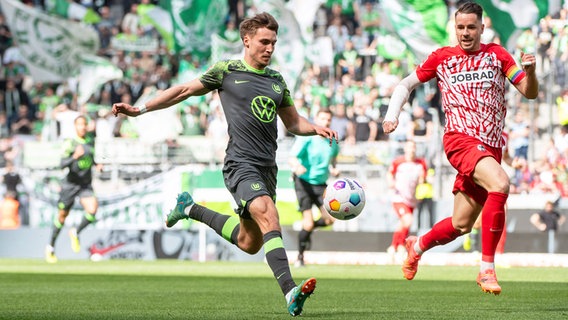 Wolfsburgs Kilian Fischer (l.) und Freiburgs Christian Günther kämpfen um den Ball. © IMAGO / Eibner 