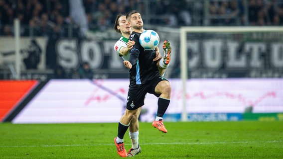 Bremens Romano Schmid (vorne) und Gladbachs Rocco Reitz kämpfen um den Ball. © IMAGO / Moritz Müller 