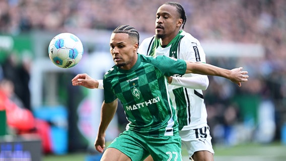 Bremens Felix Agu (l.) und Gladbachs Nathan Ngoumou kämpfen um den Ball. © Witters/TimGroothuis 