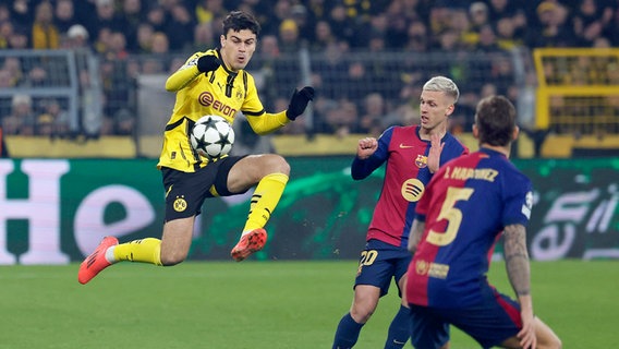 Dortmunds Giovanni Reyna (l.) behauptet den Ball im Sprung gegen Barcelonas Dani Olmo. © IMAGO / HMB-Media 