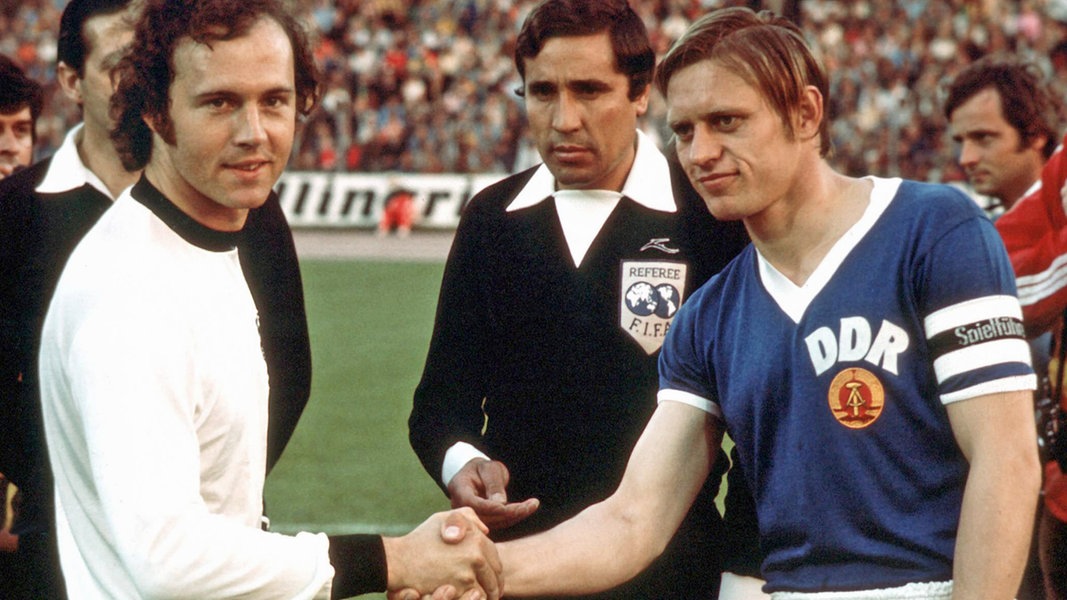 Franz Beckenbauer (l.) und Bernd Bransch schütteln sich vor dem Anpfiff der WM-Partie BR Deutschland - DDR die Hände.