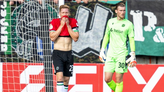 Marcel Halstenberg (l.) und Torhüter Leo Weinkauf von Hannover 96 sind enttäuscht. © picture alliance/dpa | David Inderlied 