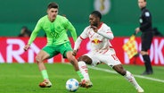 Wolfsburgs Joakim Maehle (r.) und Leipzigs Ridle Baku kämpfen um den Ball. © IMAGO / DeFodi Images 