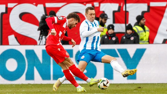 Rostocks Franz Pfanne (r.) und Yannik Möker (Energie Cottbus) kämpfen um den Ball. © IMAGO / Andy Bünning 