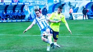 Rostocks Sigurd Haugen (l.) und Wiesbadens Felix Luckeneder kämpfen um den Ball. © IMAGO / Andy Bünning 