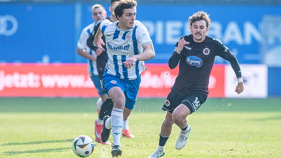 Rostocks Benno Dietze (r.) und Kölns Florian Engelhardt kämpfen um den Ball. © IMAGO / Fotostand 