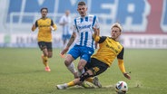 Rostocks Nico Neidhart (l.) und Dresdens Sascha Risch kämpfen um den Ball. © IMAGO / Fotostand 