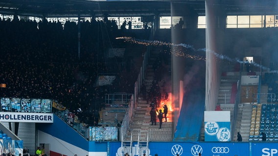 Anhänger von Dynamo Dresden und Hansa Rostock beschießen sich mit Raketen und brennen Pyrotechnik ab. © IMAGO / Ostseephoto 