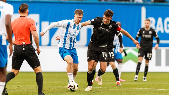 Rostocks Jonas Dirkner (l.) und Sandhausen Jakob Lewald kämpfen um den Ball. © IMAGO / Andy Bünning 