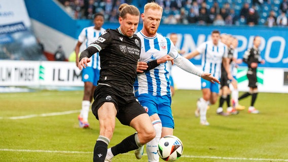 Rostocks Nils Fröling (r.) und Sandhausen Patrick Greil kämpfen um den Ball. © IMAGO / Andy Bünning 