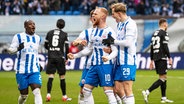 Rostocks Nils Fröling (M.) und seine Mitspieler bejubeln einen Treffer. © IMAGO / Fotostand 