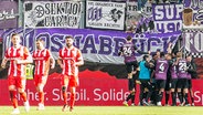 Spieler vom VfL Osnabrück bejubeln im Hintergrund einen Treffer gegen Energie Cottbus. © IMAGO / Fotostand 