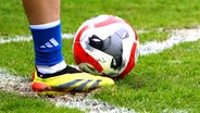 Ein Fußballschuh neben einem Fußball © IMAGO/Niklas Heiden 