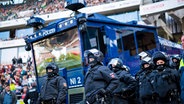 Polizeibeamte und ein Wasserwerfer im Satdion von Hannover 96 © IMAGO / Noah Wedel 