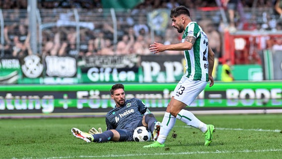 Hannovers Ron-Robert Zieler (l.) im Duell mit Münsters Malik Batmaz © IMAGO / Osnapix 