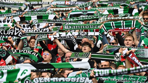 Fans von Hannover 96 halten Schals hoch. © picture alliance/dpa | Carmen Jaspersen 