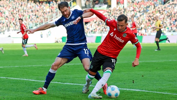 Hannovers Bartlomiej Wdowik (r.) im Zweikampf mit Karlsruhes Budu Zivzivadze © Imago Images 