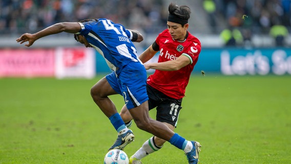 Berlins Deyovaisio Zeefuik (l.) und Hannovers Hyun-ju Lee kämpfen um den Ball © picture alliance Foto: dpa | David Inderlied