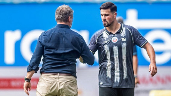 Neuzugang Ahmet Gürleyen (r.) klatscht mit Trainer Bernd Hollerbach von Hansa Rostock ab © IMAGO/Ostseephoto 