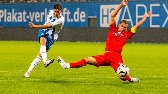 Unterhachings Sebastian Maier (r.) wirft sich in einen Schuss von Alexander Rossipal © IMAGO / Ostseephoto 