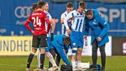 Jonas Dirkner (2.v.r.) vom FC Hansa Rostock wird vom Feld begleitet © picture alliance / Fotostand | Fotostand / Voelker 