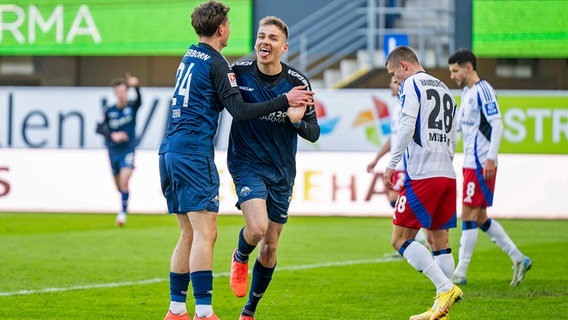 Die HSV-Spieler Miro Muheim (2.v.r.) und Daniel Elfadli gehen mit gesenktem Kopf. © picture alliance/dpa 