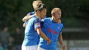 Shuto Machino (l.) und Lewis Holtby feiern ein Tor. © IMAGO / Claus Bergmann 