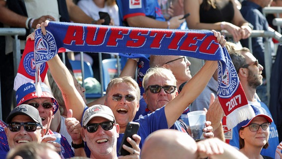 Fans von Holstein Kiel zeigen einen Schal mit dem Schriftzug "Aufstieg" © IMAGO / Susanne Hübner 