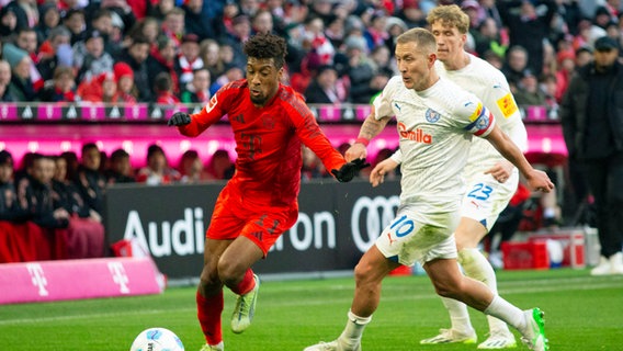 Münchens Kingsley Coman (l.) und Kiels Lewis Holtby kämpfen um den Ball. © Imago Images Foto: HMB Media Paul Fritz