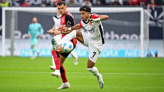 Leverkusens Granit Xhaka (l.) im Zweikampf mit Frankfurts Omar Marmoush © Imago Images 