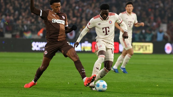 Paulis Morgan Guilavogui (l) im Zweikampf mit Münchens Alphonso Davies. © picture alliance/dpa | Christian Charisius 