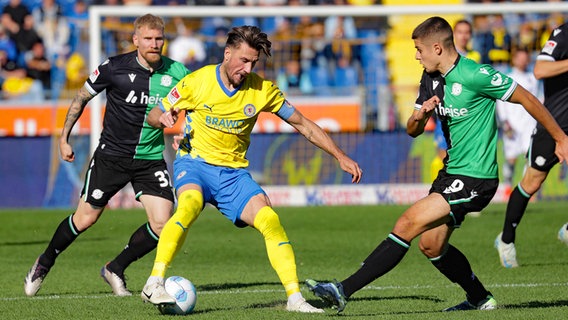 Ermin Bicakcic von Eintracht Braunschweig (M.) kämpft mit Nicolo Tresoldi (r.) und Andreas Voglsammer von Hannover 96 um den Ball © IMAGO/Susanne Hübner Foto: Susanne Hübner