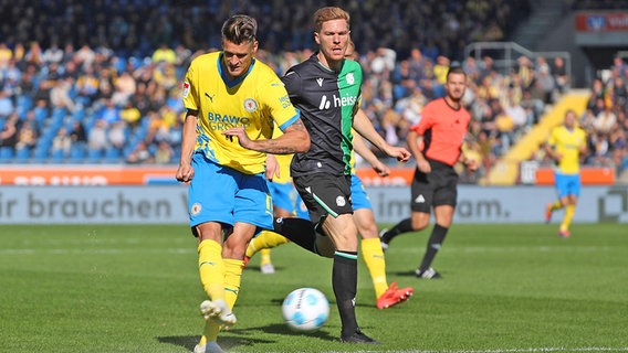 Levente Szabo (l.) von Eintracht Braunschweig im Niedersachsenderby gegen Hannover 96 beim Abschluss © IMAGO / regios24 