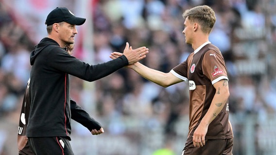 St. Paulis Trainer Alexander Blessin (l.) klatscht mit David Nemeth ab. © Witters 