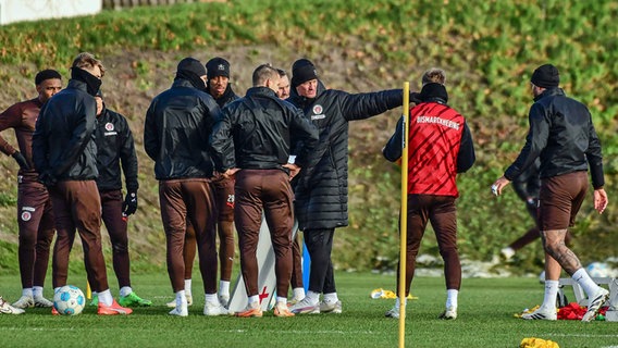 Trainer Alexander Blessin (3.v.r.) inmitten seiner Spieler. © IMAGO / Oliver Ruhnke 