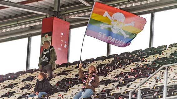 Eine Anhängerin des FC St. Pauli schwenkt vor dem Anpfiff der Partie gegen den 1. FC Heidenheim eine Fahne © imago images / foto2press 