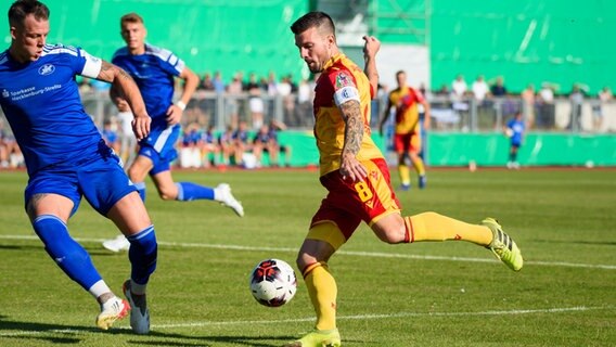 Kevin Riechert (l.) von der TSG Neustrelitz erwartet den Schuss des Karlsruhers Jerome Gondorf © picture alliance/dpa Foto: Gregor Fischer