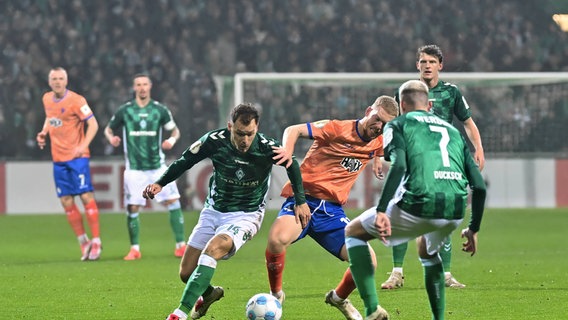 Bremens Senne Lynen (l.) und Marvin Ducksch (vorne) kämpfen um den Ball. © Nordphoto 