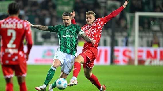 Werder Bremens Marco Friedl (l.) im Zweikampf mit dem Mainzer Nelson Weiper © picture-alliance / DPA 