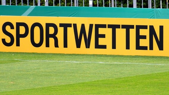 Ein Schild mit der Aufschrift "Sportwetten" auf einem Fußballplatz © imago images/Noah Wedel 