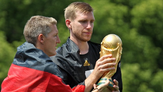 Per Mertesacker (r.) und Bastian Schweinsteiger mit dem WM-Pokal © picture alliance Foto: Stefan Matzke